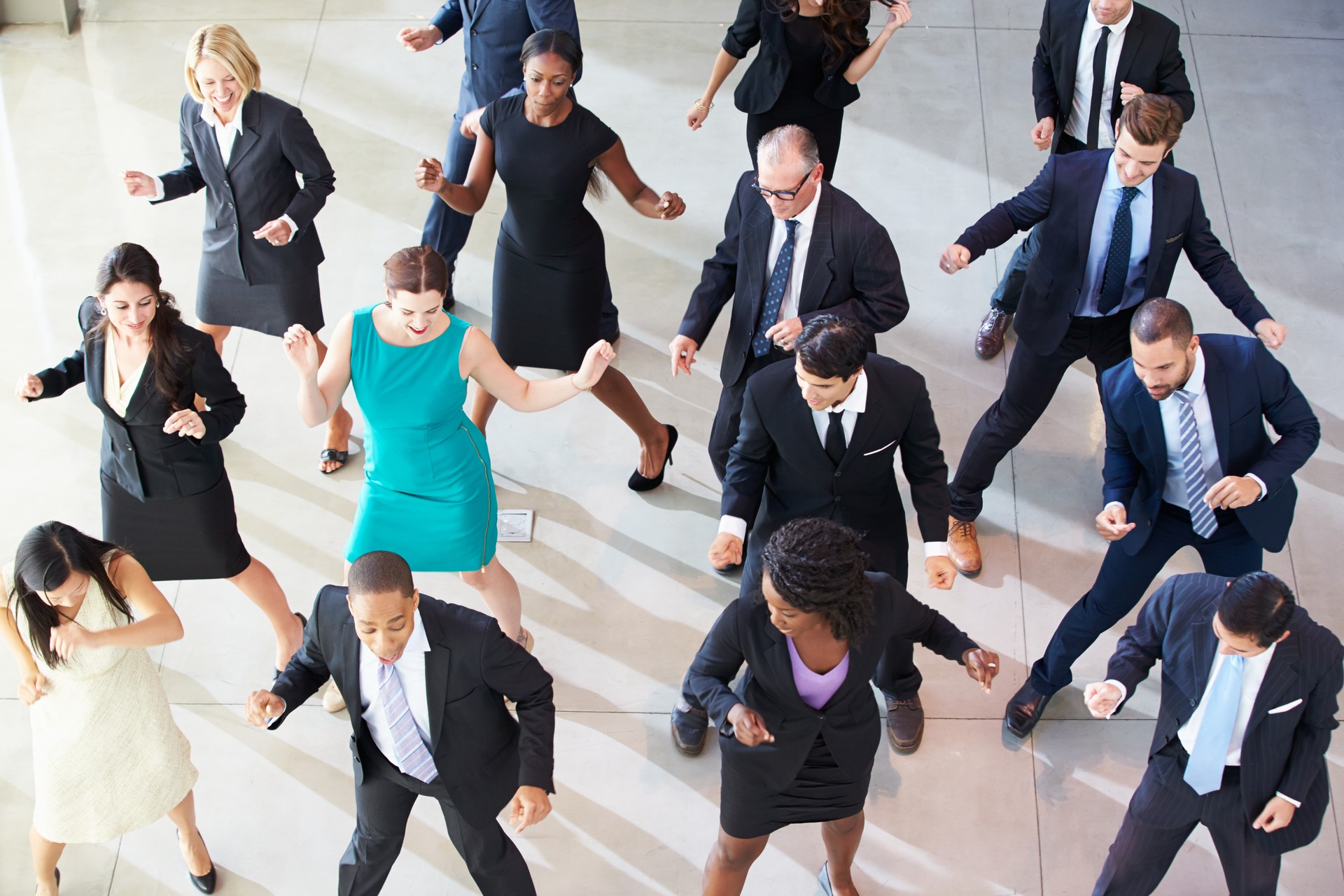 Overhead of businesspeople dancing in an office lobby